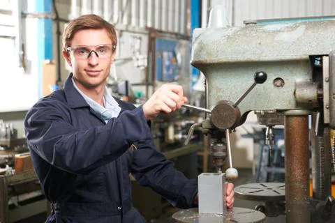 Engineer Using Drill In Factory Workshop Foto stock