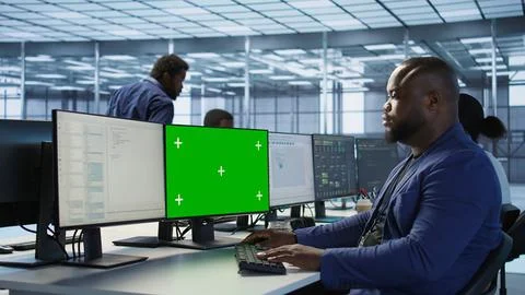 Engineer using green screen computer, working in server farm Stock Photos