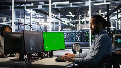 Engineer using green screen mockup PC in data center to update servers Stock Photos
