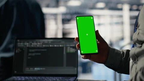 Engineer using isolated screen smartphone in server room while optimizing AI Stock Footage 314686215