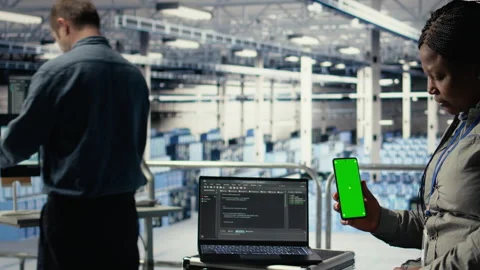 Engineer using isolated screen smartphone in server room while optimizing AI Video stock 314803128
