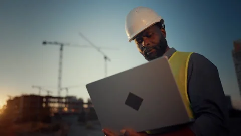 Engineer using laptop, cinematic portrait of african man at construction site Stock Footage 318342964