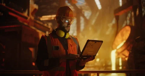 Engineer Using Laptop Computer in a Foundry Stock Footage 320868203