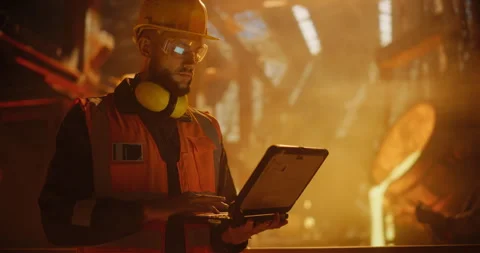 Engineer Using Laptop Computer in a Foundry Stock Footage 320868399