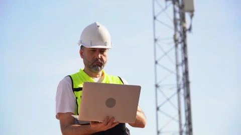 Engineer using laptop computer testing the communications tower Stock Footage 262160324