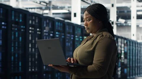 Engineer using laptop in data center, integrating new technologies Stock Photos