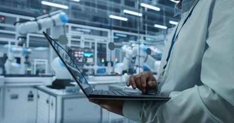 Engineer Using Laptop in Robotics Factory Stock Footage 319830174
