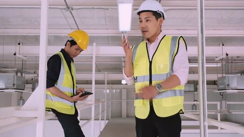 Engineer using mobile phone to contact customer with worker Stock Footage 129584601