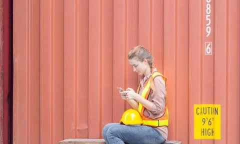 Engineer using mobile phone, Industrial worker sitting alone and holding smar 写真素材