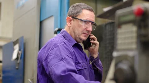 Engineer using phone while working in a cnc factory Stock-Footage 257491830