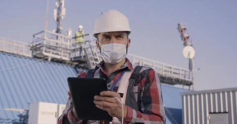 Engineer using tablet on a cellular tower Stock Photos