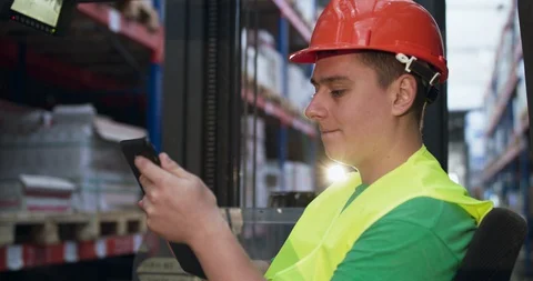 The engineer using the tablet to control the telescopic forklift in storage Vídeo Stock 127811957