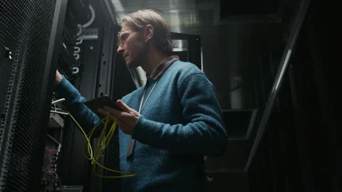 Engineer Using Tablet in Data Center while Checking Server Rack Stock Footage 330540412