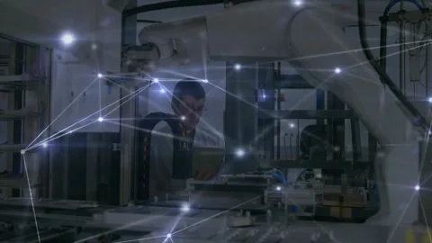 Engineer using tablet inspecting robotic cell, displaying glowing network Stock Footage 326307191