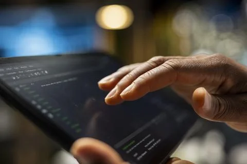 Engineer using tablet in startup office, optimizing code 스톡 사진