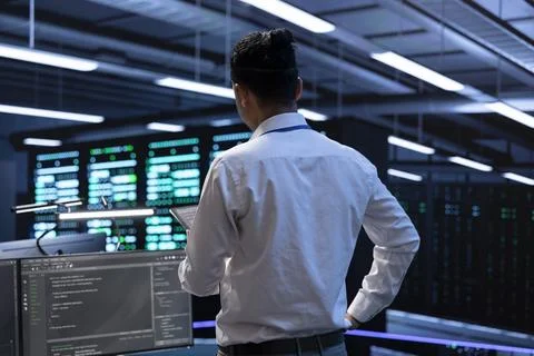 Engineer using tablet to troubleshoot hardware and software issues in server hub Stock Photos