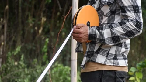 Engineer using a tape measure, farmer Measuring with Precision, Professional Stock Footage 300997296