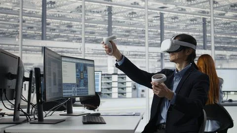 Engineer using VR technology to optimize microchip production in factory Stock Photos