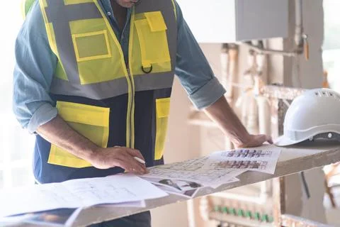 Engineer in vest studying project documentation getting ready for reconstruction Stock Photos