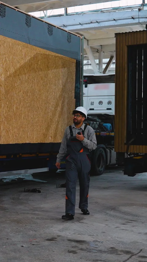 Engineer walking and talking on radio near truck Stock Footage 313091819