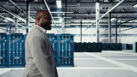 Engineer walking in data center facility, doing inspection on hardware tech 스톡 사진