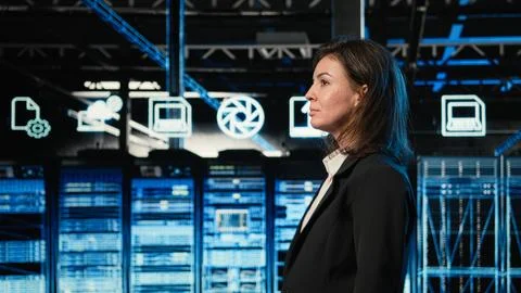 Engineer walking in data center, looking at industrial systems virtualization Stock Photos