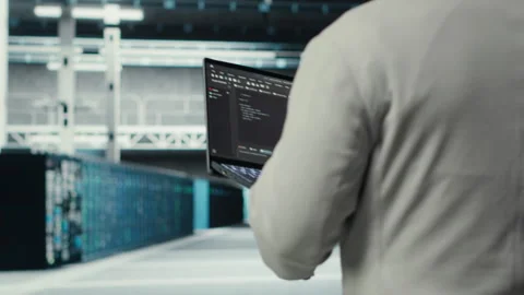 Engineer walking in data center using device to configure hardware Stock Footage 311960587