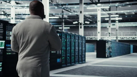 Engineer walking in data center using device to configure hardware Stock Footage 311963622