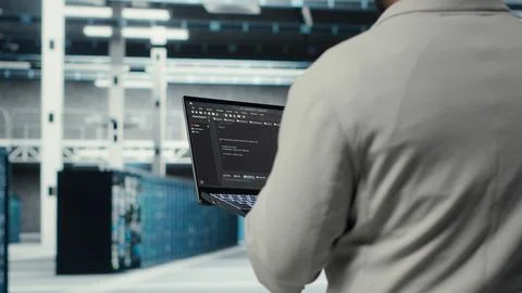 Engineer walking in data center using device to configure hardware Stock Photos
