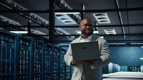 Engineer walking in data center using AI automation during maintenance session Stock Photos