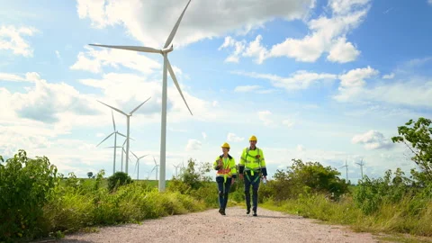 Engineer is walking in a field wearing a protective helmet on  head Stock Footage 269098318