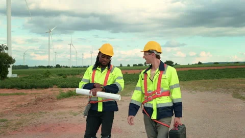 Engineer is walking in a field wearing a protective helmet on  head Stock Footage 269098322
