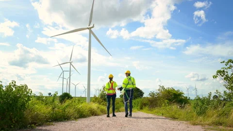 Engineer is walking in a field wearing a protective helmet on  head Stock Footage 269098375