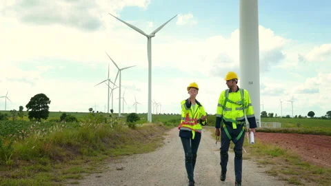 Engineer is walking in a field wearing a protective helmet on  head Stock Footage 269098731