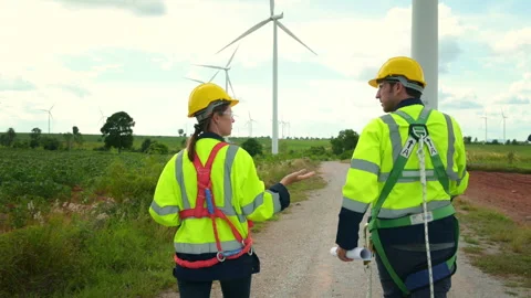 Engineer is walking in a field wearing a protective helmet on  head Stock Footage 269098786