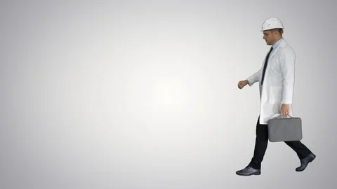 Engineer walking in a rush and looking at his watch on gradient background. Vídeos de archivo 113471279