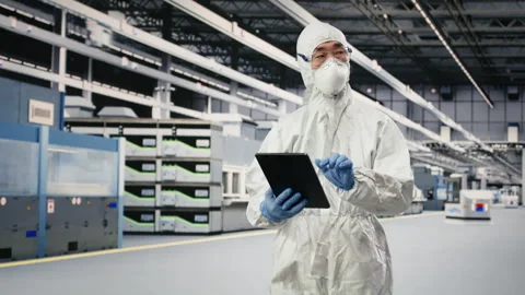 Engineer walking in semiconductor production plant floor, using tablet Stock Footage 333395478