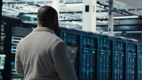 Engineer walking in server farm, automating system diagnostics 写真素材