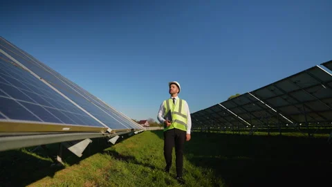 Engineer walking through solar station, checking performance data Stock Footage 296847087