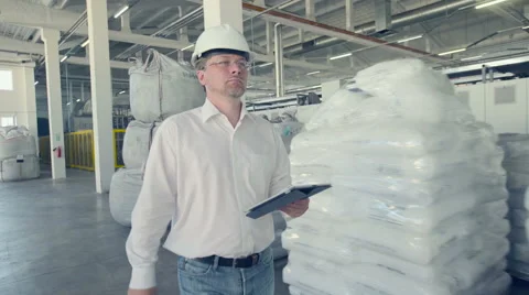 Engineer walking through warehouse part of factory Stock Footage 66244860