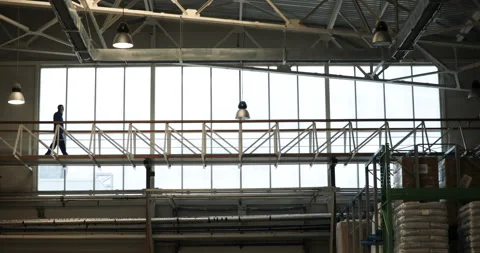 The engineer walks and talks by phone, near the window Stock Footage 91646046
