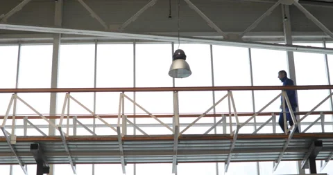 The engineer walks and talks by phone, near the window Vídeo Stock 91646579