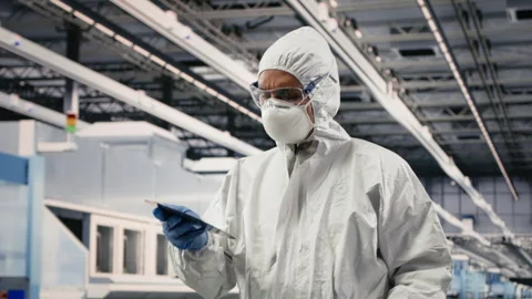 Engineer walks in semiconductor factory with tablet, working on automation Stock Footage 333394657