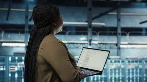 Engineer walks in server hub, using laptop to upgrade rigs Stock Footage 317125539