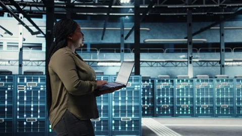 Engineer walks in server hub, using laptop to upgrade rigs Stock Footage 317206283