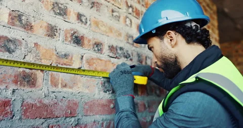 Engineer, wall and tape measure at construction site for precision, dimension Stock Footage 336779259
