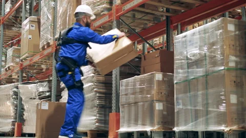 Engineer wearing exoskeleton, exosuit. Warehouse worker in exoskeleton is Stock Footage 159344482
