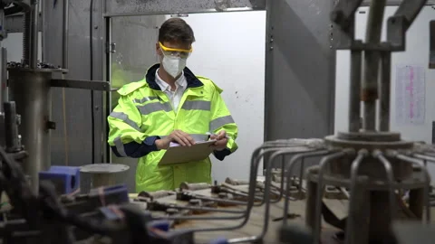 Engineer wearing face mask and protection glasses holding clipboard checking Stock-Footage 159663677