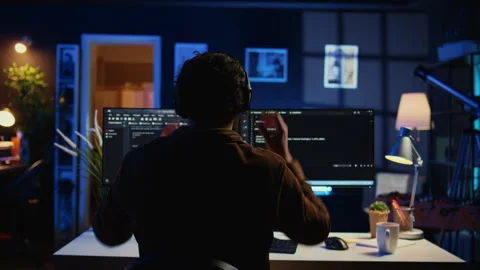 Engineer wearing headphones while using coding to fortify IT security Stock Footage 265618029