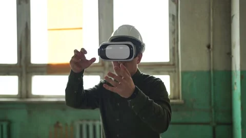 An engineer wearing virtual reality glasses moves digital objects with his hands Stock Footage 152755673